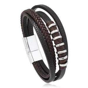 Détail d'un bracelet multicouche en cuir marron avec cordons tressés et fermoir magnétique