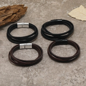Detail of four-piece braided leather bracelets with heart magnetic clasps on stone background