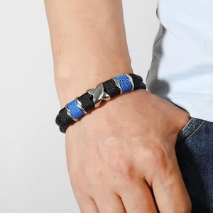 Men's double-layered woven leather bracelet with silver X-shaped metal charm on male wrist