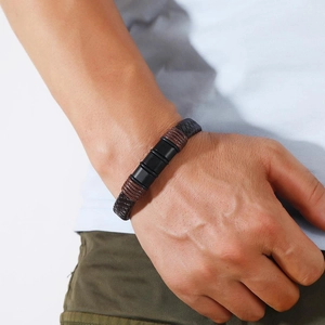 Macro detail of men's braided black and brown leather bracelet with matte magnetic beads