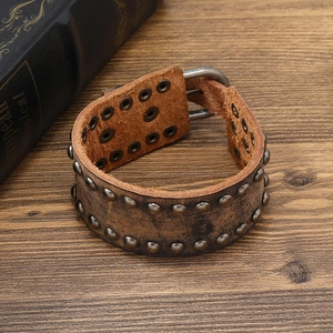 Detail of vintage brown leather bracelet featuring double-row studs and adjustable buckle