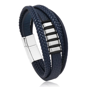 Dettaglio di un bracciale multistrato in pelle blu intrecciata con ciondoli e chiusura magnetica