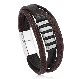 Dettaglio di un bracciale in pelle multistrato con tubi in metallo argento e chiusura magnetica