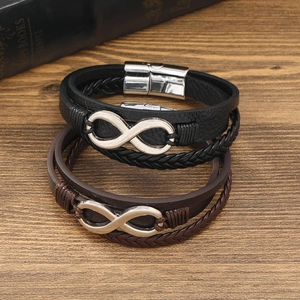 Detail view of woven leather infinity bracelets with silver magnetic clasps on wood