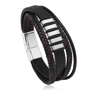 Dettaglio di un bracciale in pelle multistrato con fili intrecciati e chiusura magnetica in argento