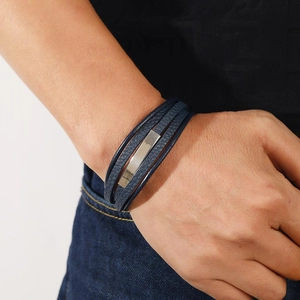 Close-up of a men's multi-layer navy leather bracelet with a silver metal plate detail