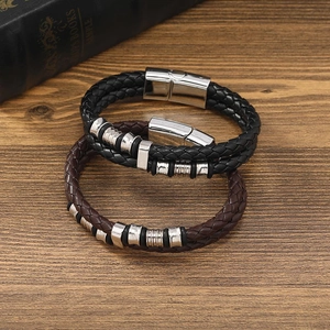 Detail of woven black and brown leather bracelets with polished magnetic metal clasps