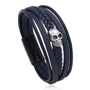 Detail of navy blue multilayer braided leather bracelet with silver skull and magnetic clasp