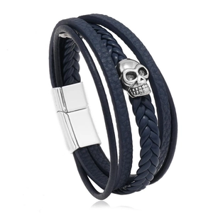 Detail of dark blue multilayer braided leather bracelet with silver skull charm and magnet clasp