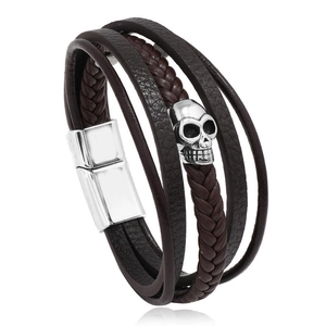 Macro detail of men's leather bracelet with silver skull charm and magnetic clasp