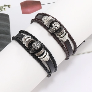 Vue détaillée de bracelets en cuir tressé multicouches avec breloques crâne en métal