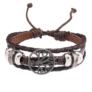 Détail du bracelet en cuir marron à plusieurs rangs avec breloque arbre de vie et perles