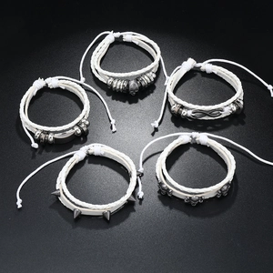 Close-up of five-piece punk bracelet set featuring skull and infinity metal charms