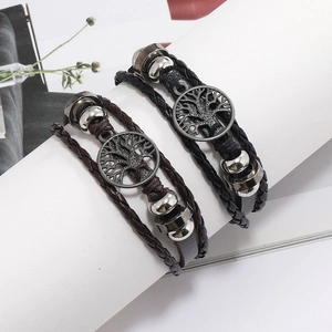 Détail de bracelets multicouches en cuir tressé avec breloques Arbre de Vie