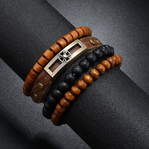 Detail of vintage multilayer men's leather bracelet with cross emblem and wooden beads