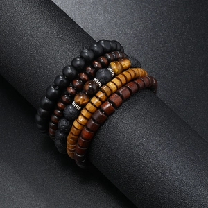 Close-up of four-piece men's beaded bracelet set with tiger eye, lava rock and wood beads