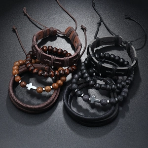 Detail of multi-layer leather bracelets with wooden beads and silver cross charms