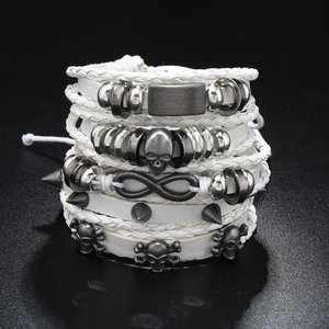 Detail of white punk layered leather bracelets with skull and infinity metal charms