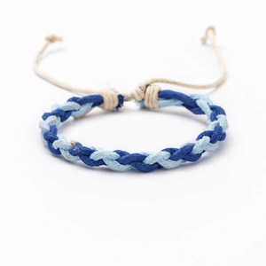 Detailed macro view of woven blue cotton cord friendship bracelet with adjustable knot
