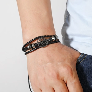 Détail du bracelet en cuir tressé multicouche avec pendentif arbre de vie sur poignet