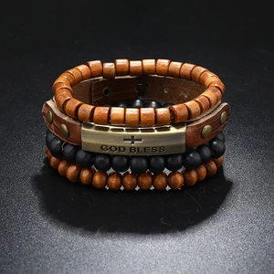 Detail of vintage leather bracelet set with wooden beads and God Bless metal plate