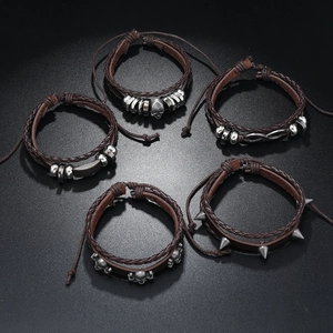 Detail of five punk leather bracelets showing skull and infinity charms with braided cords