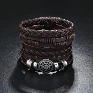 Detail of multi-layer braided brown leather bracelet with silver sunflower metal charm