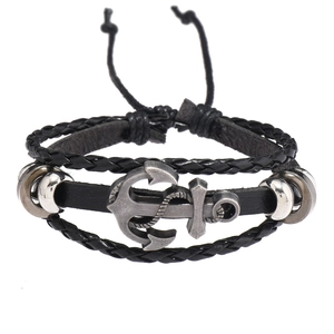 Détail d'un bracelet multicouche pour homme en cuir avec un pendentif ancre argenté
