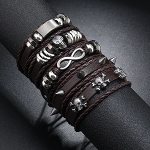 Detail of multilayer punk leather bracelet with silver skull charms and infinity symbol