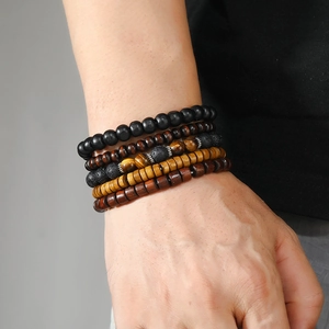 Close-up of men's multi-layered beaded bracelets with tiger eye stone and lava rock