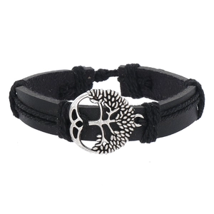 Detail of multi-layer black leather bracelet with silver tree of life metal pendant