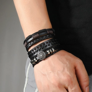 Macro detail of multilayer braided leather bracelet with silver punk gear pendant on wrist