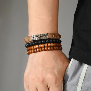 Detail of multi-layered men's bracelet set with cross metal plate and wooden beads