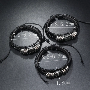 Macro view of 3-piece set leather bracelets with skull, star and peace sign metal charms