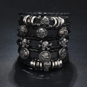 Detail of multi-layer punk leather bracelet set with skull charms and braided rope cords