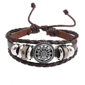 Détail du bracelet multicouche en cuir tressé avec pendentif soleil et perles en métal