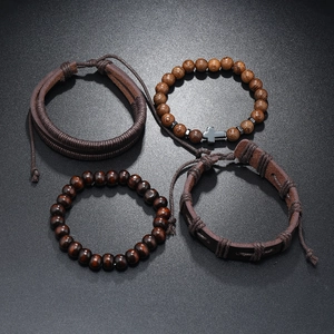 Close-up of four-piece men's bracelet set with leather braids and hematite cross
