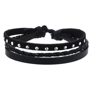 Detailed view of multilayer black leather bracelet with silver rivets and adjustable cord