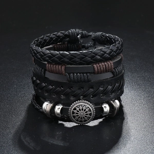 Macro detail of multi-layer braided leather bracelets with silver metal sunflower charm
