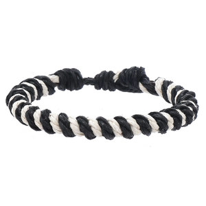 Detail of black and white spiral woven rope bracelet with adjustable knot and handcrafted texture