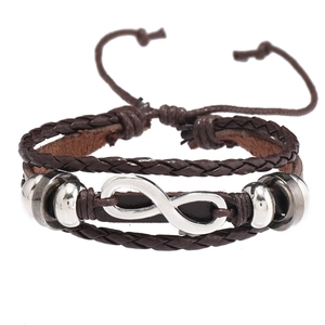 Détail d'un bracelet multicouche en cuir tressé avec un symbole infini argenté