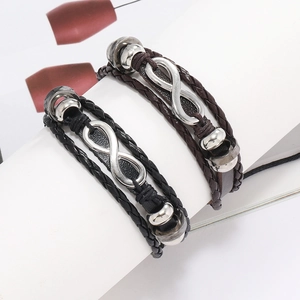 Détail de bracelets tressés en cuir avec charmes infini en argent et perles métalliques