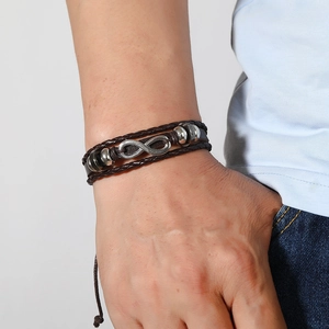 Détail macro du bracelet multicouche en cuir pour homme avec symbole infini et perles