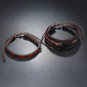 Detail of men's leather bracelets with cross charms and multi-layer braided design