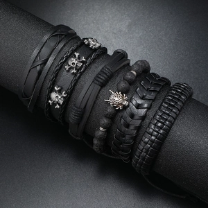 Men's punk leather bracelet set with wolf and skull charms on display stand