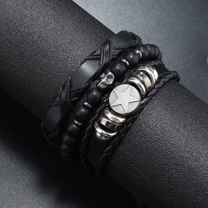 Detail of men's layered leather bracelet set with matte beads and skull metal charms