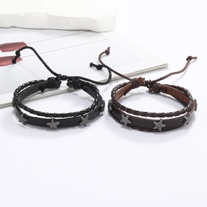 Gros plan de bracelets multicouches en cuir tressé avec des étoiles en métal vintage