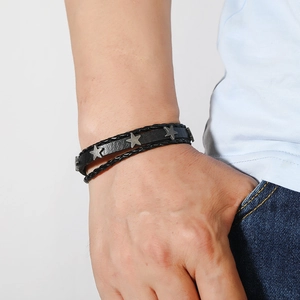 Détail d'un bracelet pour homme en cuir tressé noir orné de charmes étoiles en argent
