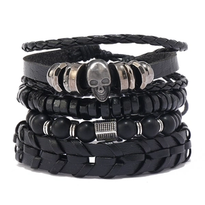 Men's multi-layer black matte bead and woven leather skull bracelet set on white background