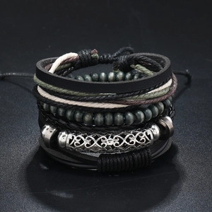 Detail of multi-layer leather bracelet with wooden beads and engraved metal tube charm